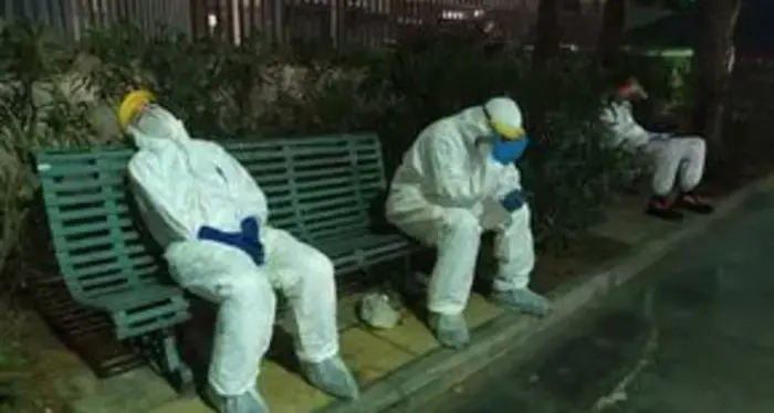 Gli operatori del 118 a Sassari \"stremati, bardati con tute protettive, costretti a code estenuanti davanti agli ospedali (in alcuni casi anche di 12 ore) in attesa che i pazienti dentro le ambulanze possano accedere ai Pronto Soccorso dell'isola\". Questa