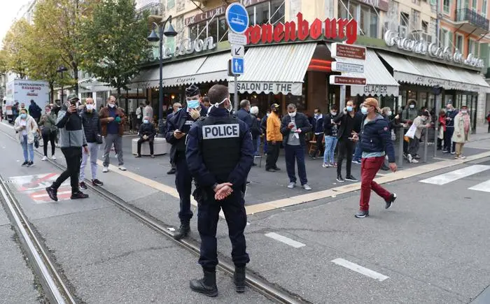 French policemen stand guard a street after a knife attack in Nice on October 29, 2020. - A man wielding a knife outside a church in the southern French city of Nice slit the throat of one person, leaving another dead and injured several others in an attack on Thursday morning, officials said. The suspected assailant was detained shortly afterwards, a police source said, while interior minister Gerald Darmanin said on Twitter that he had called a crisis meeting after the attack. (Photo by Valery HACHE / AFP)