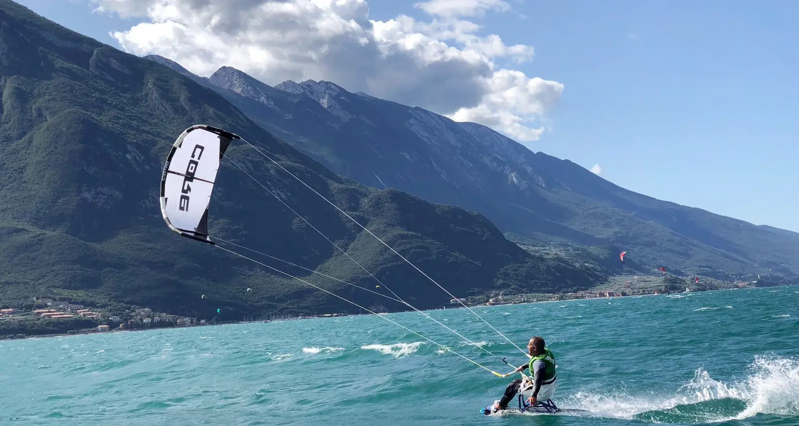 I paraplegici che volano con il kitesurf sul lago con la tavola per carrozzina