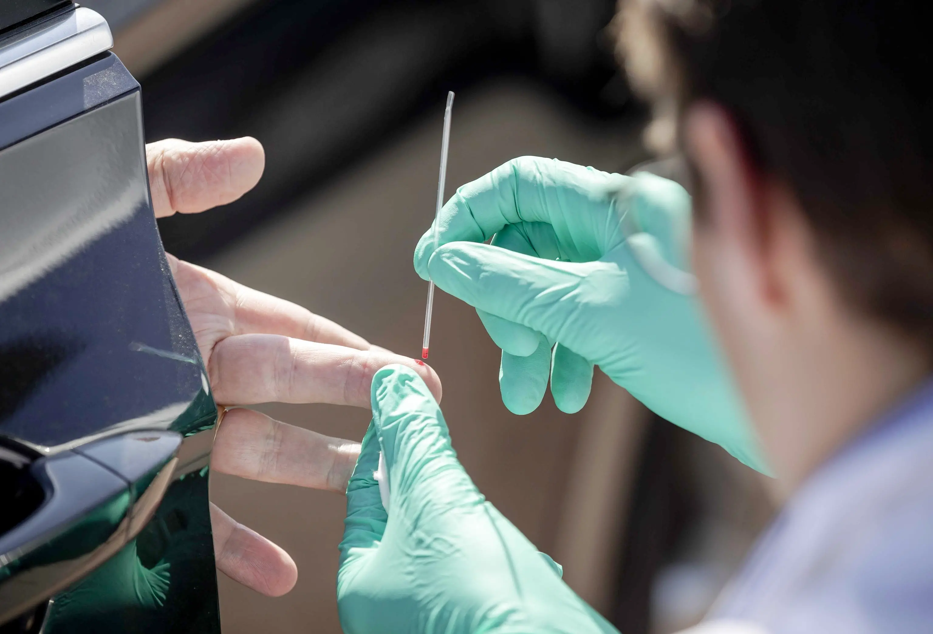 epa08364476 A health worker collects samples from a motoritst to test for antibodies against the coronavirus disease (COVID-19) at a drive-through center in Oss, The Netherlands, 15 April 2020. At the drive-through of Innatoss Laboratories and the IMTest Foundation, people can get tested whether they have had the coronavirus infectious disease. EPA/ROBIN VAN LONKHUIJSEN