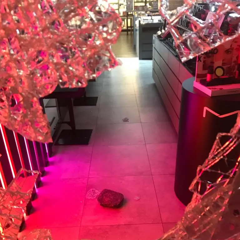 Raptus di follia: una donna spacca la vetrina a sassate in via Oss Mazzurana - IL VIDEO