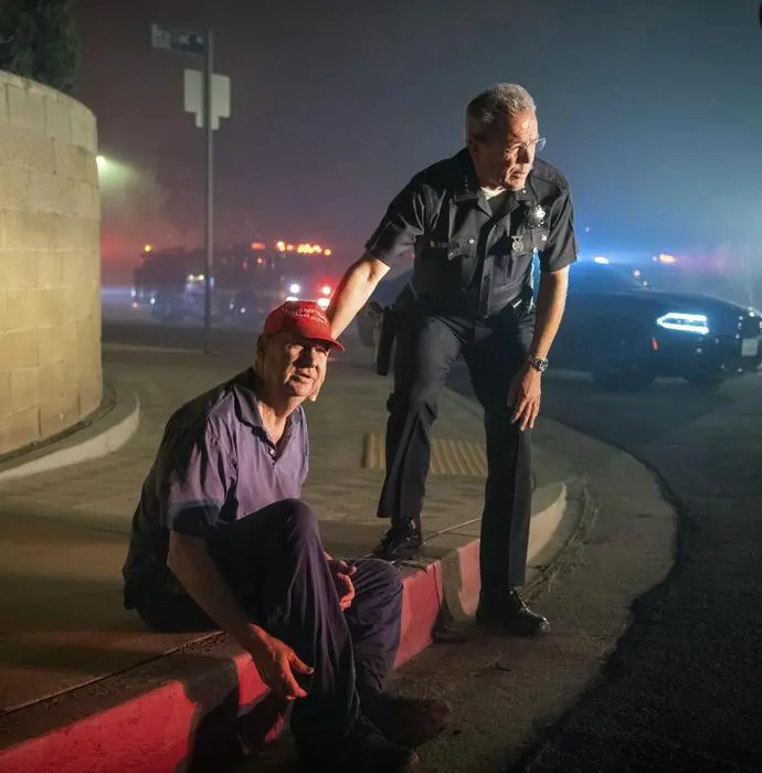 Los Angeles Police Department Chief Michel Moore tells resident Jerry Rowe that firefighters are coming after the roof of Rowe's home caught fire from the Saddleridge fire in Granada Hills, Calif., Friday, Oct. 11, 2019. (ANSA/AP Photo/Michael Owen Baker) [CopyrightNotice: Copyright 2019 The Associated Press. All rights reserved.]