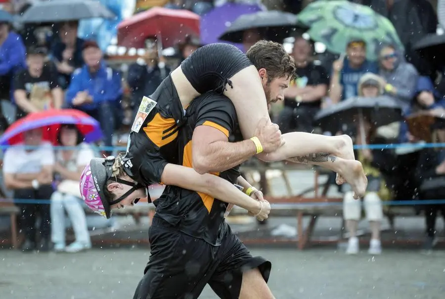 epa07699383 Competitors Dylan Hedges and Alana Flemming from Austria participate in the annual Wife Carrying World Championships in Sonkajarvi, Finland, 06 July 2019. People from all over the world took part in the event that was founded in 1992. EPA/MAURI RATILAINEN