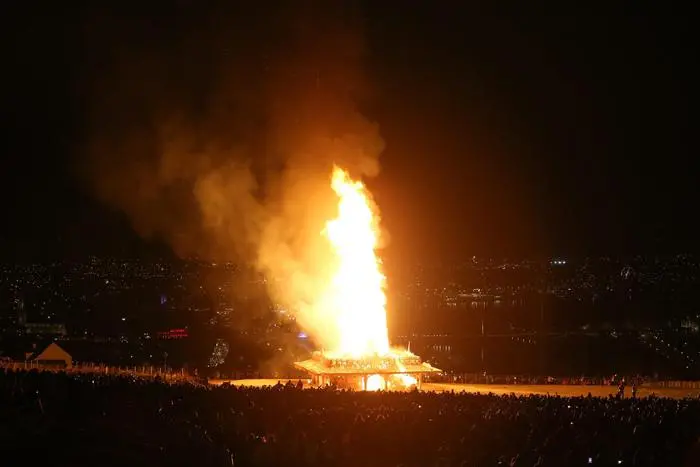 epa04673829 The 'Temple in Londonderry' made by US sculptor David Best known for its participation in the Burning Man festivals, burns during the ceremonial torched ceremony in Londonderry, Northern Ireland, 21 March 2015. The temple has been used as a space for contemplation and remembrance and people have been leaving messages inside the structure. Made from a timber frame, some sections have been designed and cut by young people from Derry under the artist direction. EPA/PAUL MCERLANE