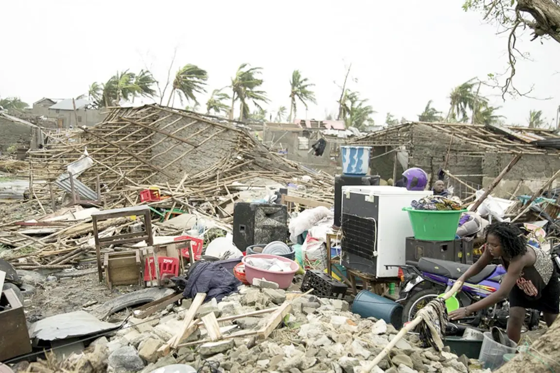 In this photo taken on Friday, March 15, 2019 and provided by the International Red Cross, a woman hangs a cloth to dry in a sea of rubble after Tropical Cyclone Idai, in Beira, Mozambique. Mozambique's President Filipe Nyusi says that more than 1,000 may have by killed by Cyclone Idai, which many say is the worst in more than 20 years. Speaking to state Radio Mozambique, Nyusi said Monday, March 18 that although the official death count is currently 84, he believes the toll will be more than 1,000. (Denis Onyodi/IFRC via AP) [CopyrightNotice: IFRC Climate Centre]