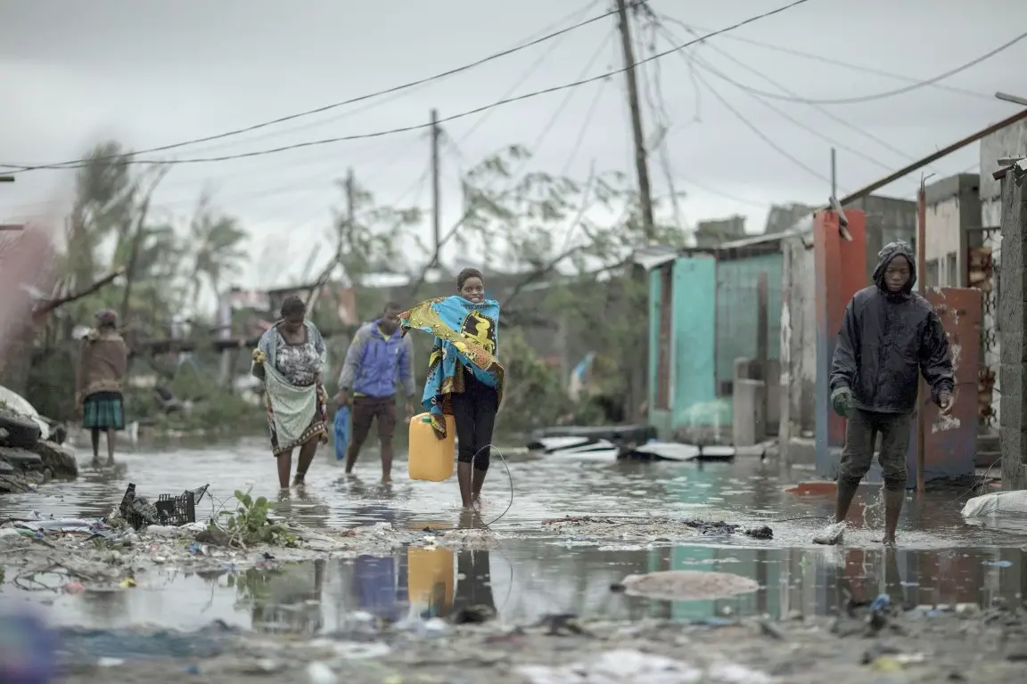 People return to Praia Nova Village, one of the most affected neighbourhoods following a cyclone in the coastal city of Beira, Mozambique, Sunday March 17, 2019. Families are returning to the vulnerable shanty town following cyclone high winds and rain. More than 1,000 people are feared dead in Mozambique four days after a cyclone slammed into the southern African country. (Josh Estey/CARE via AP)
