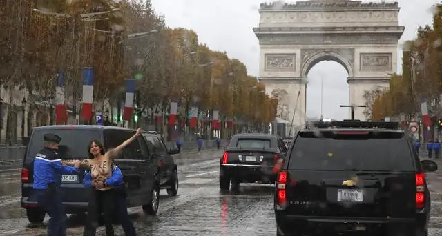 Passa l'auto di Trump, la Femen scavalca