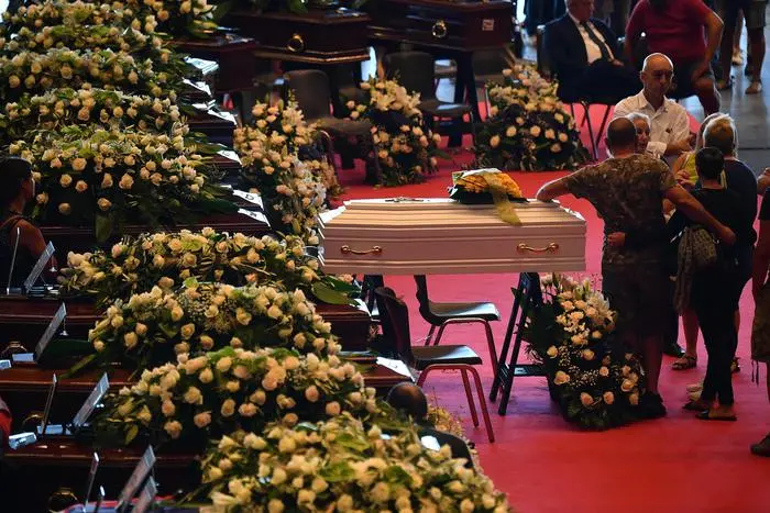 Victims of the Morandi bridge disaster lie in coffins at the Fiera di Genova exhibition centre prior to the State funeral, in Genoa, Italy, 18 August 2018. The Morandi bridge partially collapsed on 14 August, killing at least 41 people. ANSA/LUCA ZENNARO