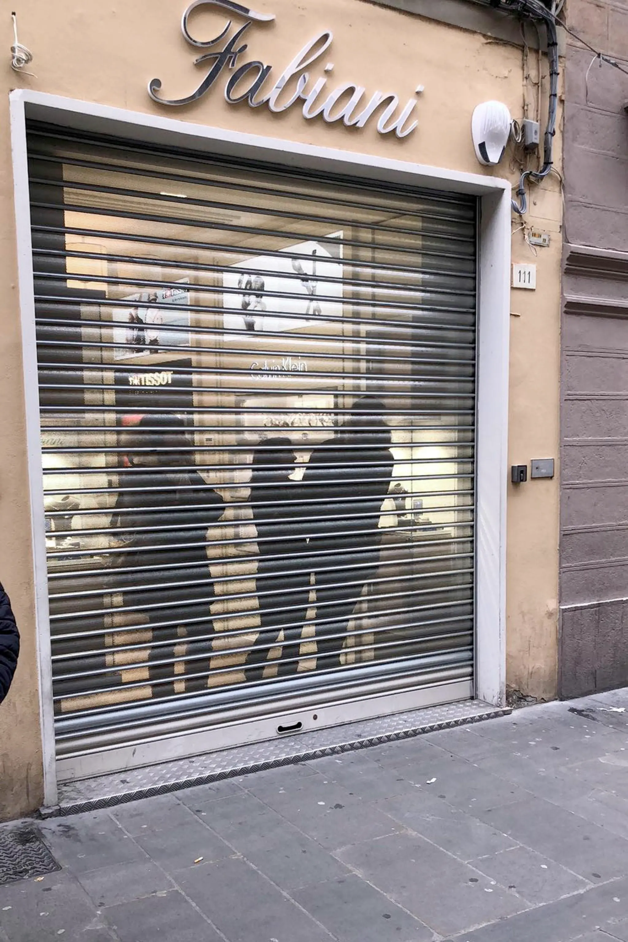 Una saracinesca chiusa di un negozio mentre i manifestanti dei centri sociali e dell'area antagonista protestano per il comizio di Matteo Salvini a Pisa, 23 febbraio 2018. ANSA