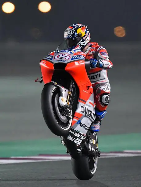 epa06608529 Italian MotoGP rider Andrea Dovizioso of Ducati Team does a wheelie during a free practice session for the Motorcycling Grand Prix of Qatar at Al Losail International Circuit in Doha, Qatar, 16 March 2018. The 2018 MotoGP World Championship season's first race will be held in Doha on 18 March. EPA/NOUSHAD THEKKAIL