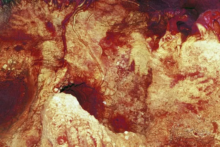 This color enhanced image provided by Hipolito Collado Giraldo in February 2018 shows three hand stencils in the Maltravieso Cave in Cáceres, Spain. One has been dated to at least 66,000 years ago. New discoveries in some Spanish caves give the strongest evidence yet that Neanderthals created art. (Hipolito Collado Giraldo via AP)