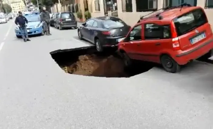 Un frame tratto da un video postato su twitter da Francesca De Candia mostra una maxi voragine che si è aperta in strada a Roma, tra due auto in sosta, in circonvallazione Appia. +++ATTENZIONE LA FOTO NON PUO' ESSERE PUBBLICATA O RIPRODOTTA SENZA L'AUTORIZZAZIONE DELLA FONTE DI ORIGINE CUI SI RINVIA+++
