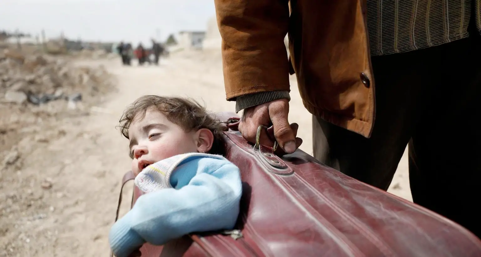 Siria, ancora bombe e morti. Esodo da Afrin La foto simbolo del bambino in una valigia