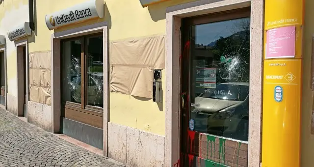 Scritte contro Unicredit Vetrate danneggiate