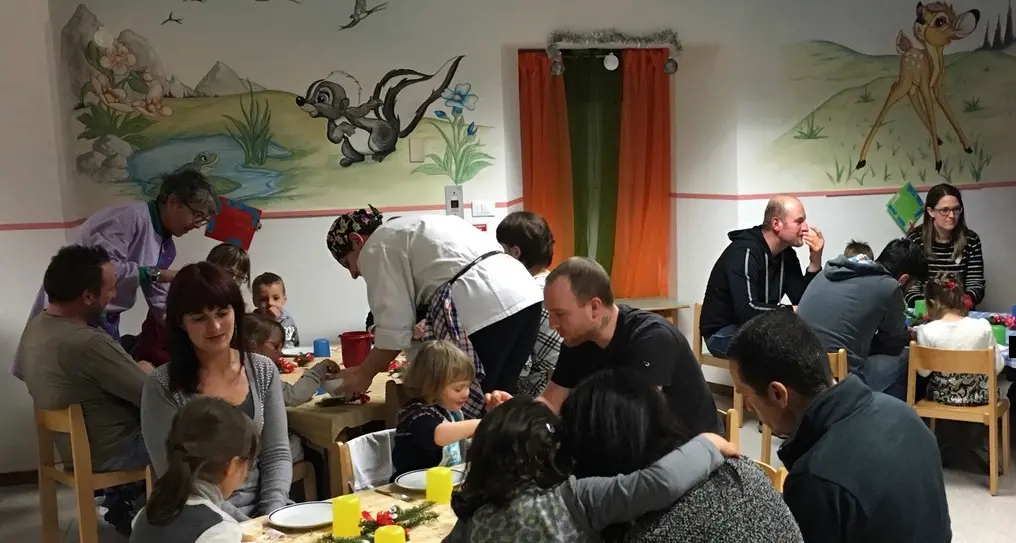 Mamma e papà a cena all'asilo invitati dai loro piccoli figli
