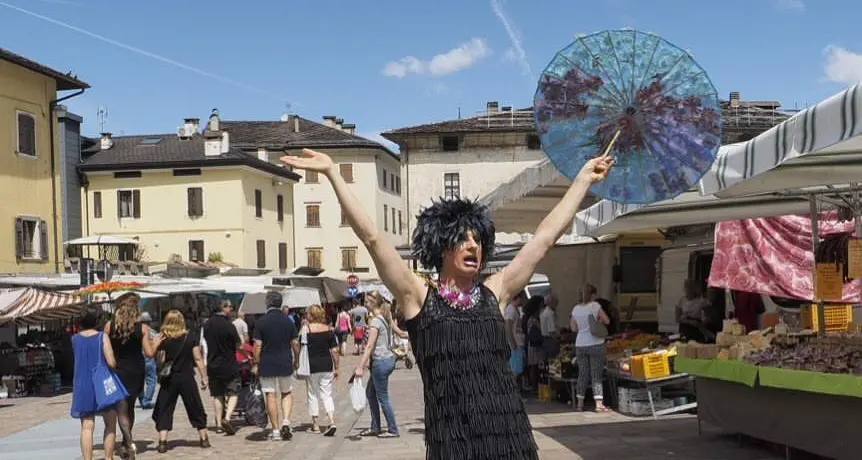 Una «drag queen» a spasso per il mercato di Pergine