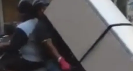 Trasportano un frigorifero con lo scooter tra le vie di Napoli