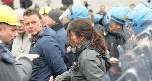 Ilva, la poliziotta si toglie il casco e stringe la mano ai lavoratori