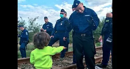 L'innocenza del bambino siriano che offre un biscotto al poliziotto