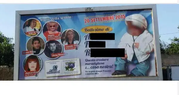 Rimossi i poster del neonato con la coppola bianca per il battesimo