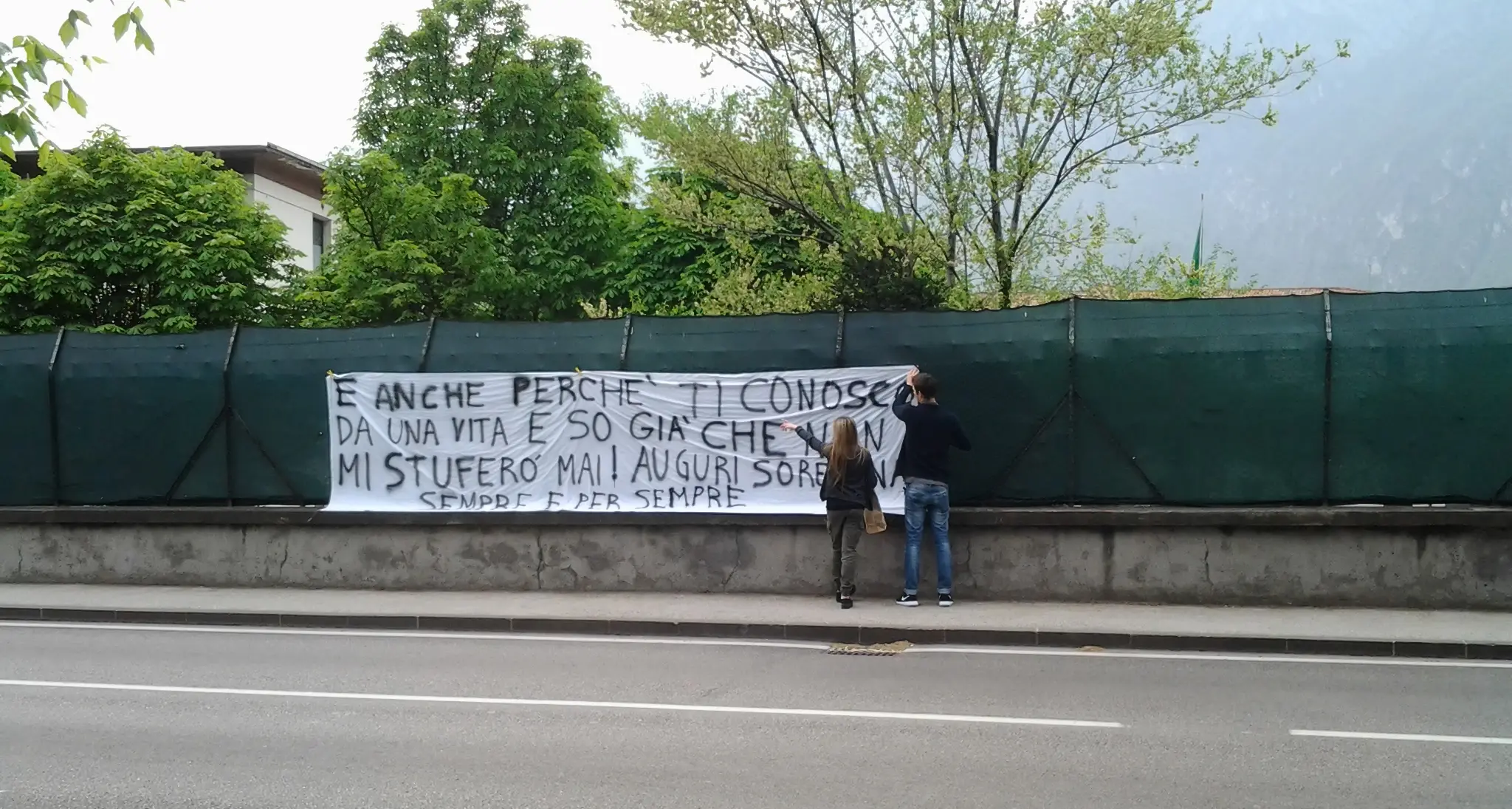 Gli auguri con un mega striscione all'uscita di scuola