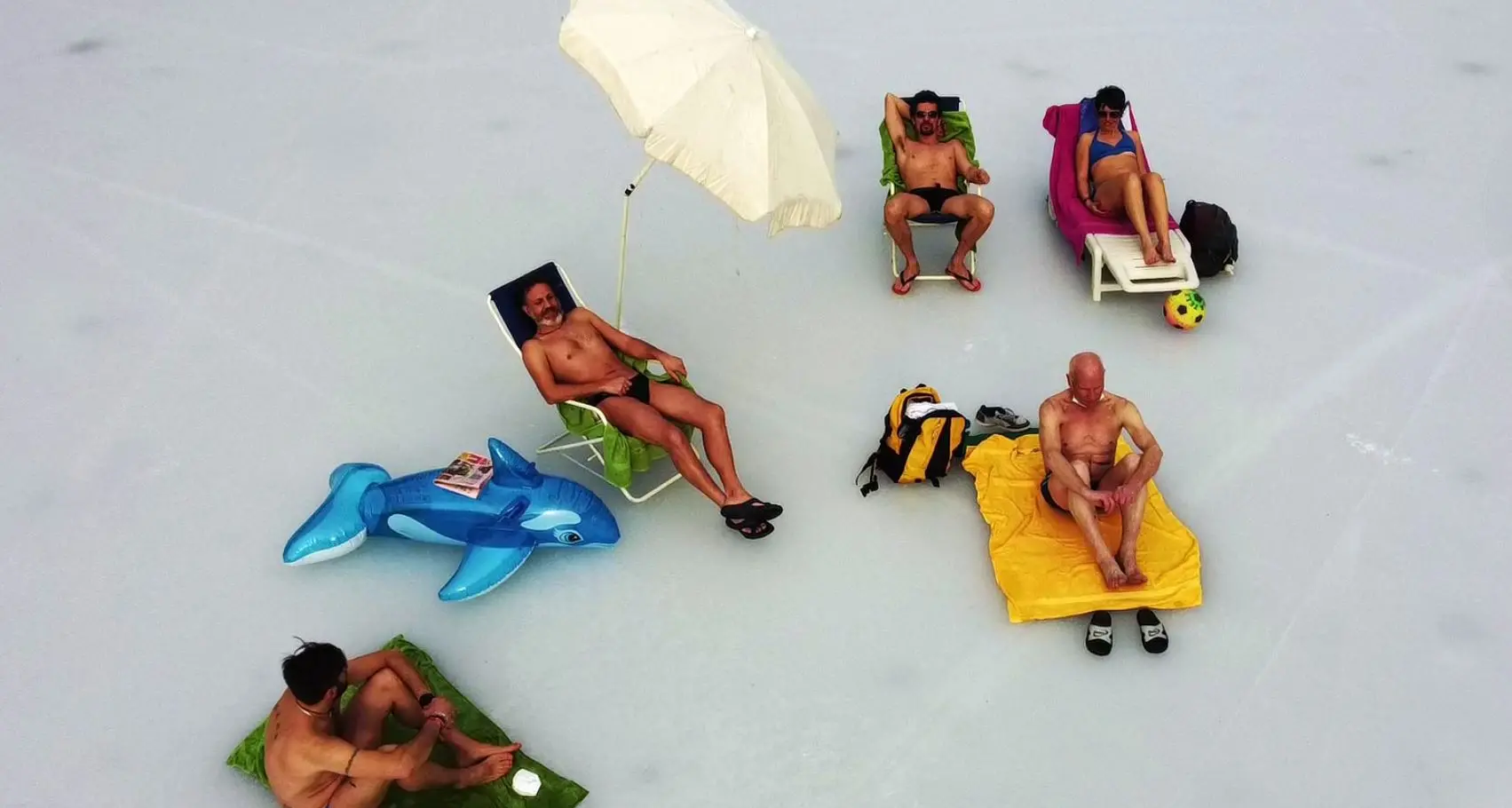Ledro, niente \"Tuffo della Merla\", ma gli organizzatori vanno in spiaggia: sdraio, ombrellone e costume sul ghiaccio