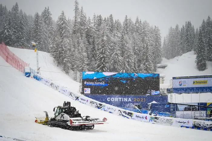 A snowcat clears the snow in the arrival area of the FIS Alpine World Ski Championships on the eve of the first race in Cortina d'Ampezzo, Italian Alps, on February 7, 2021. - The February 8-21 World Ski Championships in Cortina d'Ampezzo, Italy, will feature 600 male and female skiers from more than 70 countries racing in 13 events. (Photo by Fabrice COFFRINI / AFP)