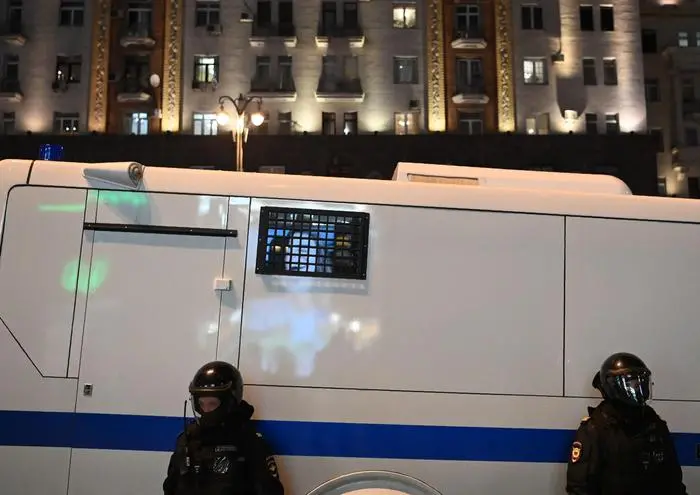 Russian riot police officers patrol near a police bus with an advertising photo reflecting on a window during a rally in support of jailed Kremlin critic Alexei Navalny, in Moscow on April 21, 2021. - Jailed Kremlin critic Alexei Navalny's team called for demonstrations in more than 100 cities, after the opposition figure's doctors said his health was failing following three weeks on hunger strike. (Photo by Kirill KUDRYAVTSEV / AFP)