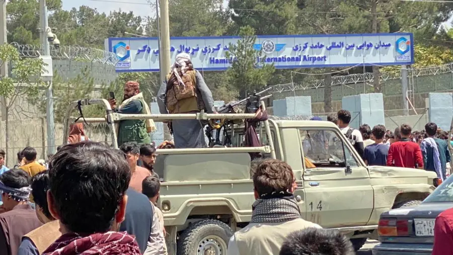 epa09416070 Taliban stands guard outside the Hamid Karzai International Airport as people walk to the airport to flee the country after rumors that foreign countries are evacuating people even without visas, in Kabul, Afghanistan, 16 August 2021. Taliban co-founder Abdul Ghani Baradar Monday declared victory and end to the decades-long war in Afghanistan, a day after the insurgents entered Kabul to take control of the country. Baradar, who heads the Taliban political office in Qatar, released a short video message after President Ashraf Ghani fled and conceded that the insurgents had won the 20-year war. EPA/STRINGER