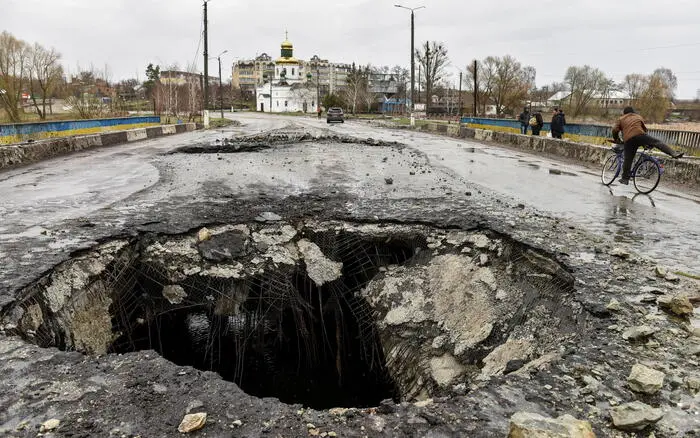 epa09879909 A shell crater on a damaged bridge in the recaptured city of Makariv, outside Kyiv (Kiev), Ukraine, 09 April 2022. Ukrainian authorities said that over 400 bodies were discovered following the Russian armyâ€™s retreat from towns surrounding Kyiv, prompting international calls for a probe into possible war crimes committed by Russia. EPA/OLEG PETRASYUK