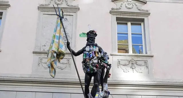 Bolzano, blitz ambientalista: la statua di Nettuno vestita di rifiutI raccolti sui prati del Talvera