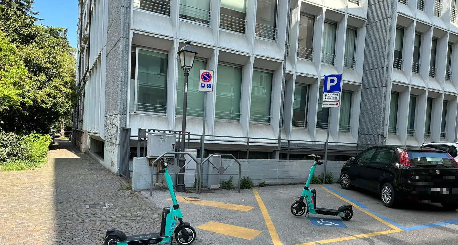 Monopattini abbandonati in giro per Trento: anche nel mezzo di un parcheggio riservato ai disabili