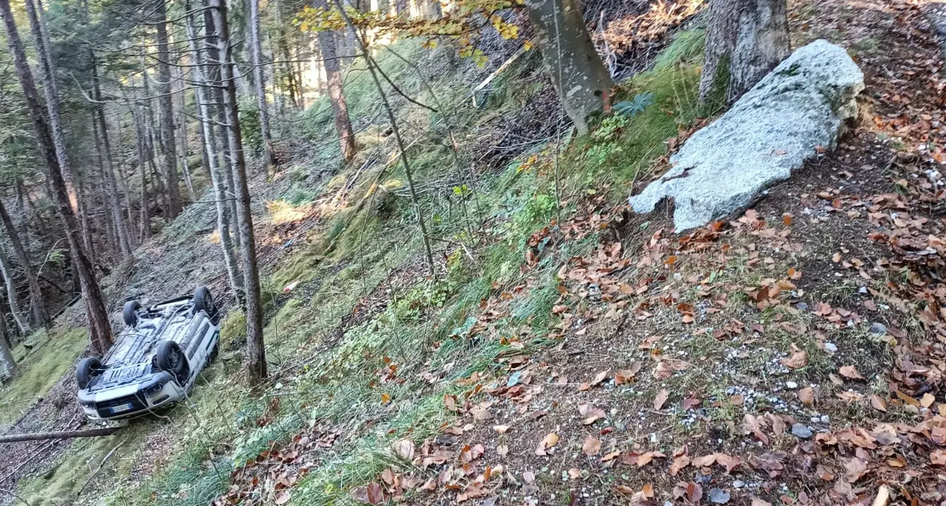 Problema con il freno a mano, l'auto finisce ruote all'aria in mezzo agli alberi