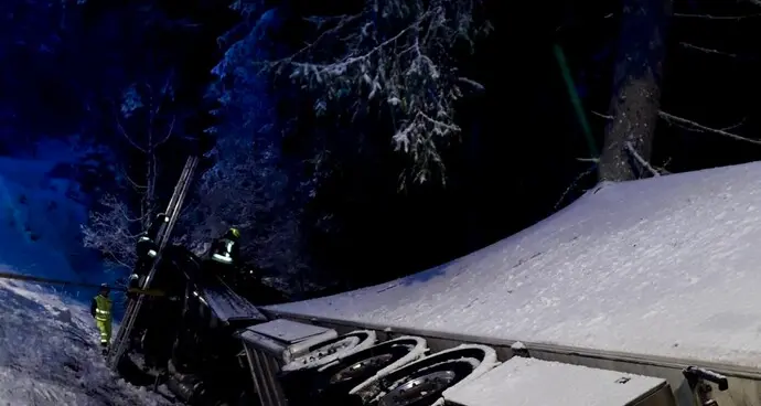 Dobbiaco, nevica e un tir finisce nel burrone fra gli alberi
