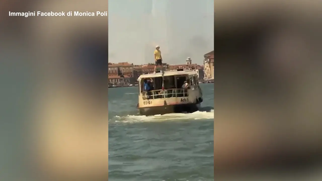 In piedi sopra un vaporetto, bravata nel centro di Venezia