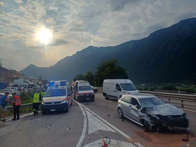 Incidente stradale su strada di montagna, mezzi danneggiati in carreggiata, soccorritori al lavoro, traffico bloccato
