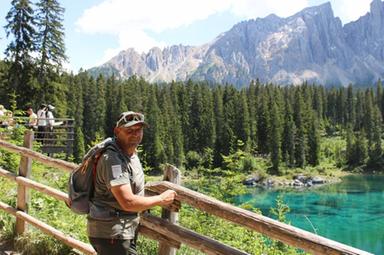 Uomo a difesa di un lago alpino tra le Dolomiti con montagne sullo sfondo