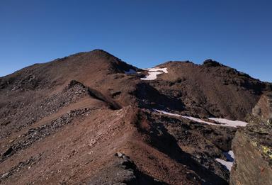 Paesaggio montano alpino innevato con versanti rocciosi e ghiaccio perenne, Trentino