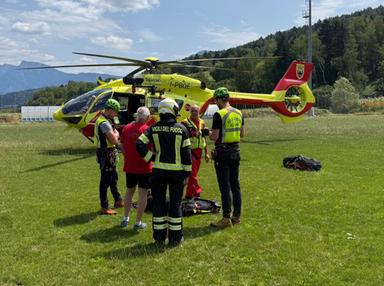 Elisoccorso in azione su montagna rocciosa con soccorritore e ferito in zona impervio