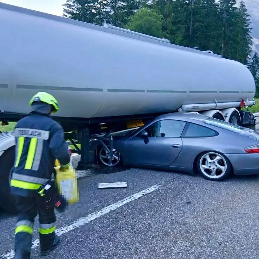Porsche finisce sotto un'autocisterna: trascinata per 30 metri