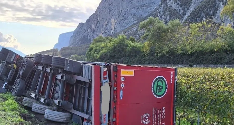 Tir si ribalta alla rotatoria, bottiglie nei campi a Sarche, il carico è andato in frantumi