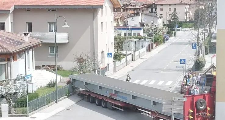 Il Tir che trasporta un pezzo del ponte si incastra tra le case a Storo