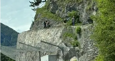 I turisti che passeggiano sopra la rete paramassi del cantiere di Mezzolago