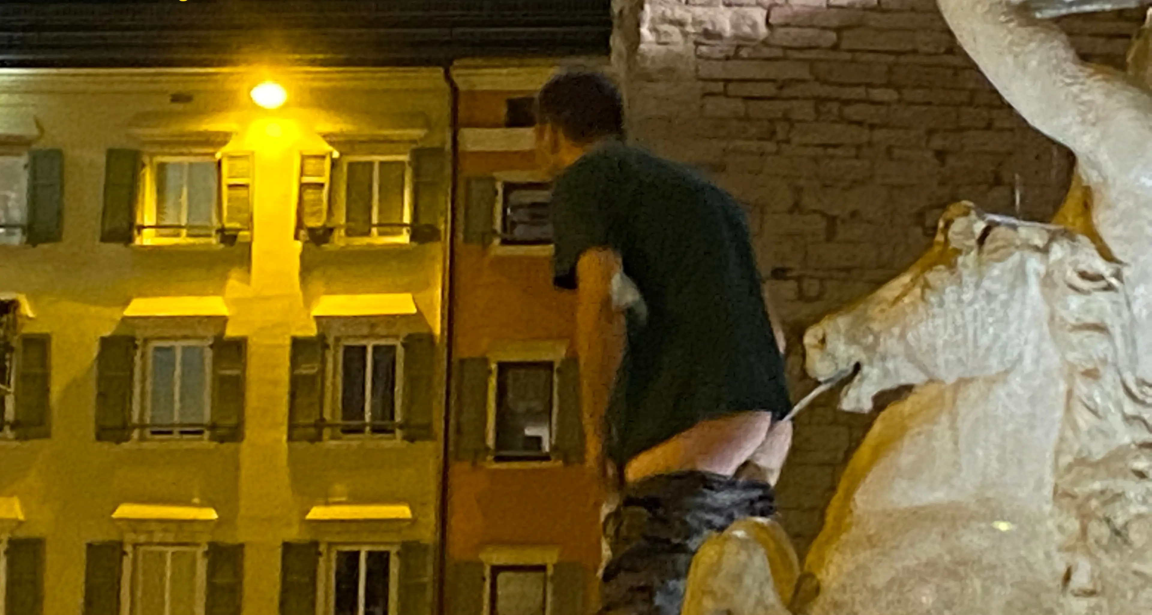 Follia in piazza Duomo: sale sulla fontana del Nettuno e mostra i genitali, e gli amici lo applaudono