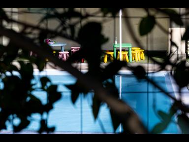 Piscina di centro estivo con corsia d'acqua vuota, nastro di sequestro giallo-nero attorno alla struttura