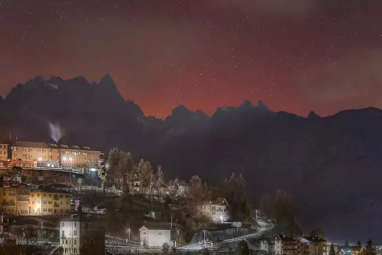 L'aurora boreale colora di rosso il cielo sulle Dolomiti