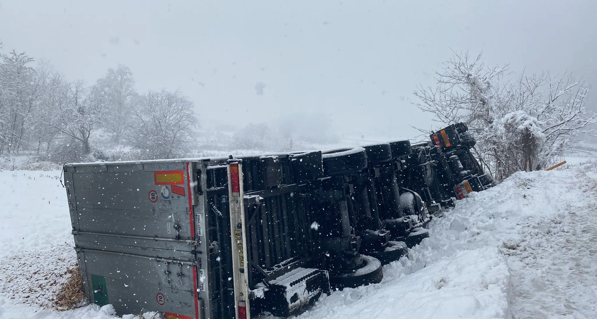 Il Tir esce di strada nella neve e si ribalta: perde il carico, l’autista estratto con le pinze idrauliche dalle lamiere