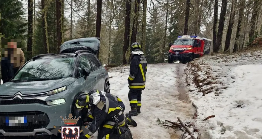 Auto bloccata nella neve: per montare le catene devono arrivare i pompieri
