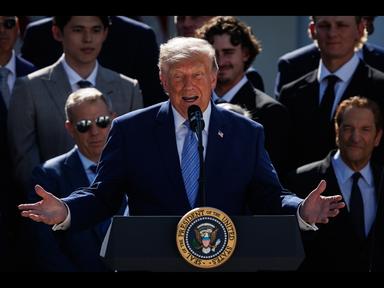 Donald Trump al podio, sfondo Casa Bianca, gesto minaccioso delle mani mentre parla