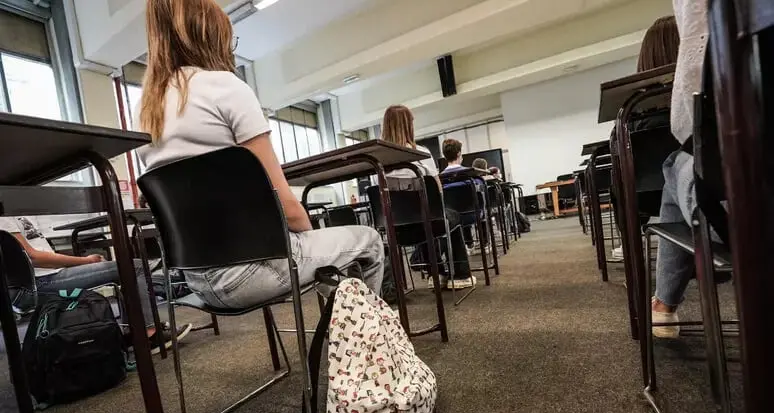 Per spiegare il riassunto la docente taglia i capelli di due alunne in classe